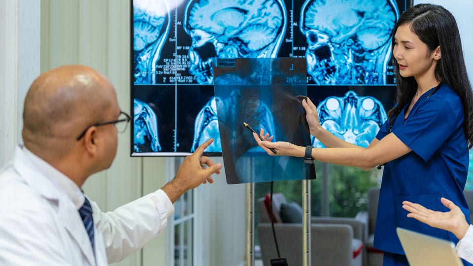 Radiologist and nurse observing MRIs