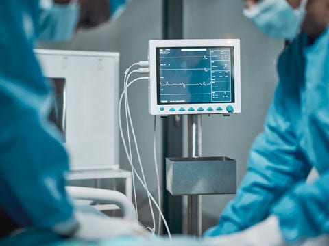 A modern operating room with digital surgical monitors and connected equipment